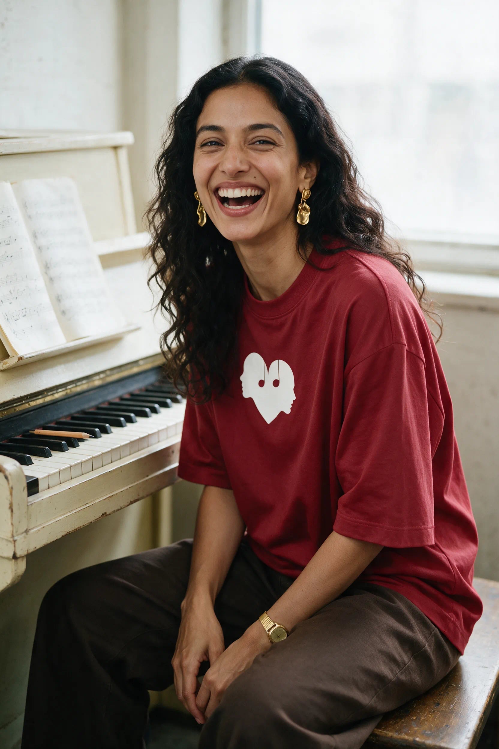 Woman at a piano in the Crimson Overture Oversized Tee