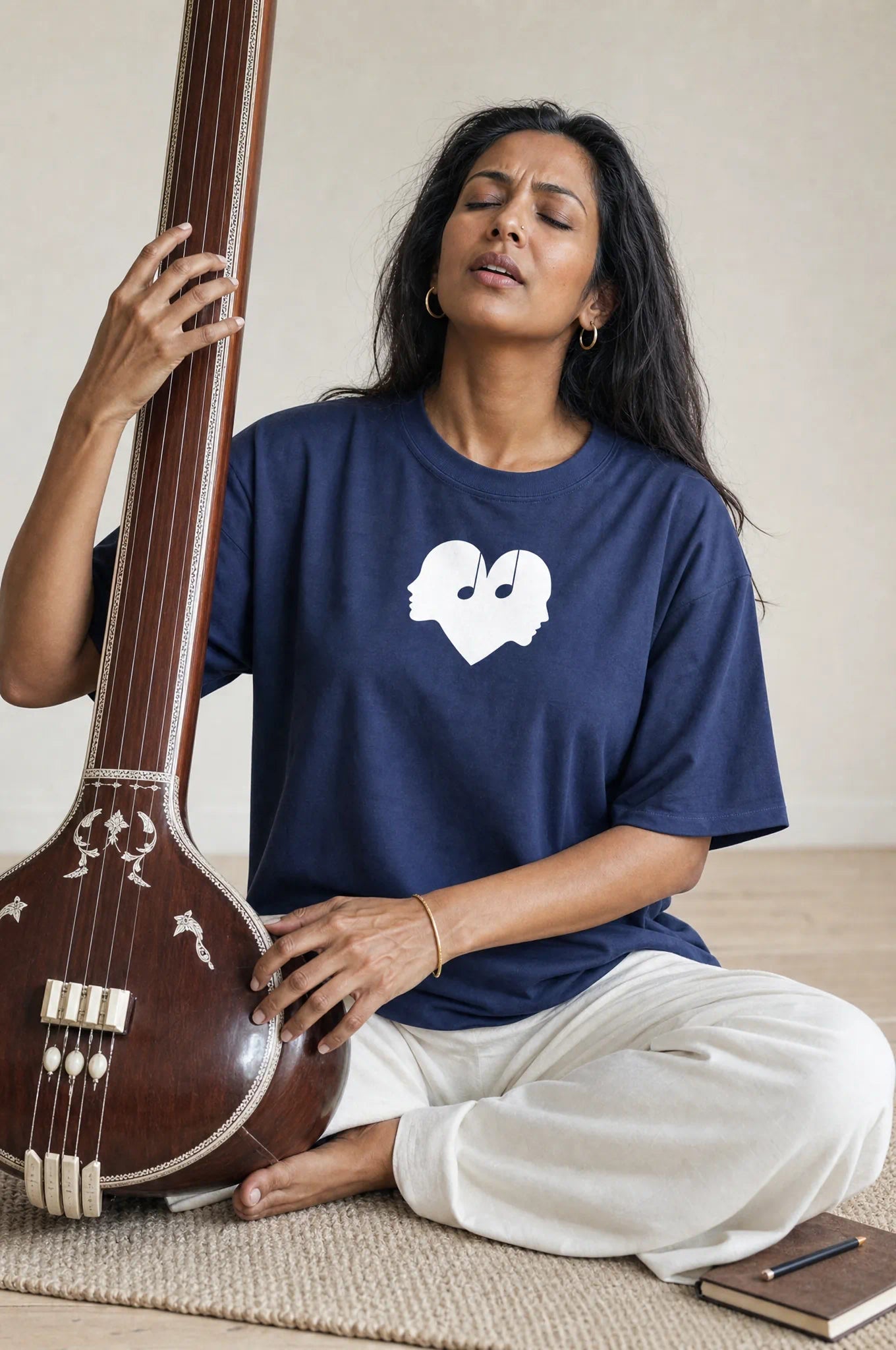Woman playing the sitar in the Midnight blue Overture Oversized Tee