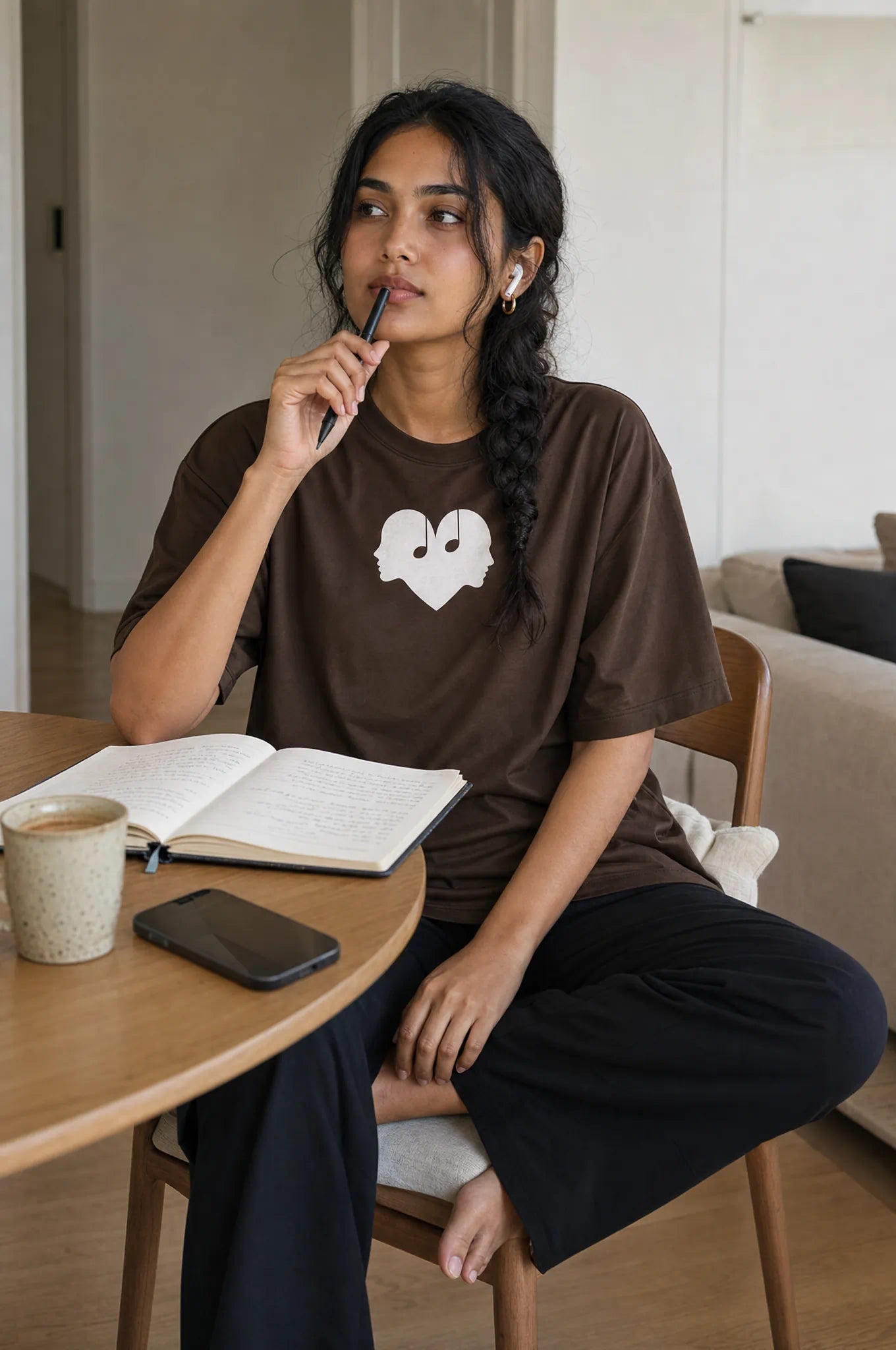 Woman lost in thought in the Mocha Overture Oversized Tee