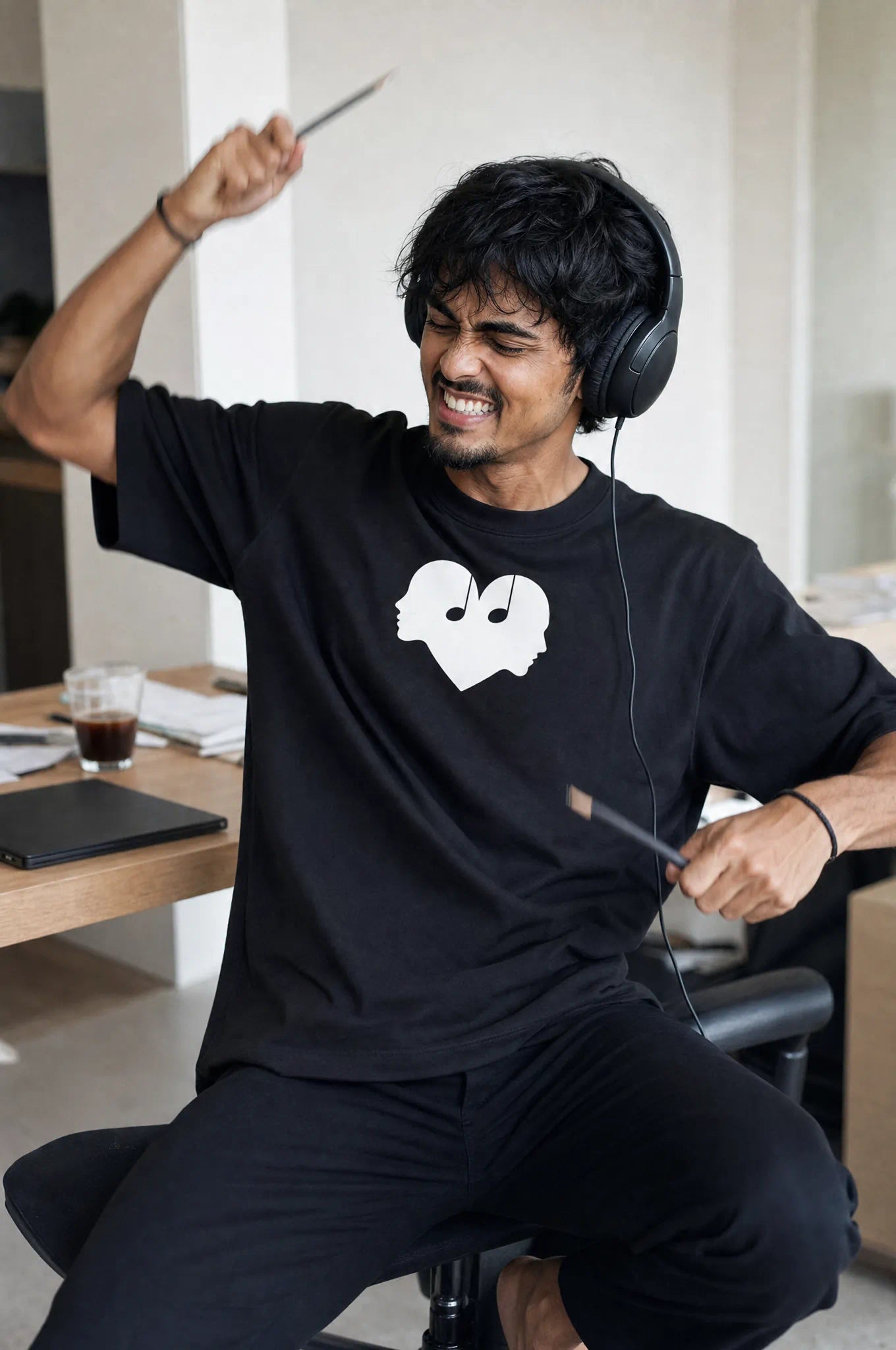 Man playing air drums in the Piano black Overture Oversized Tee