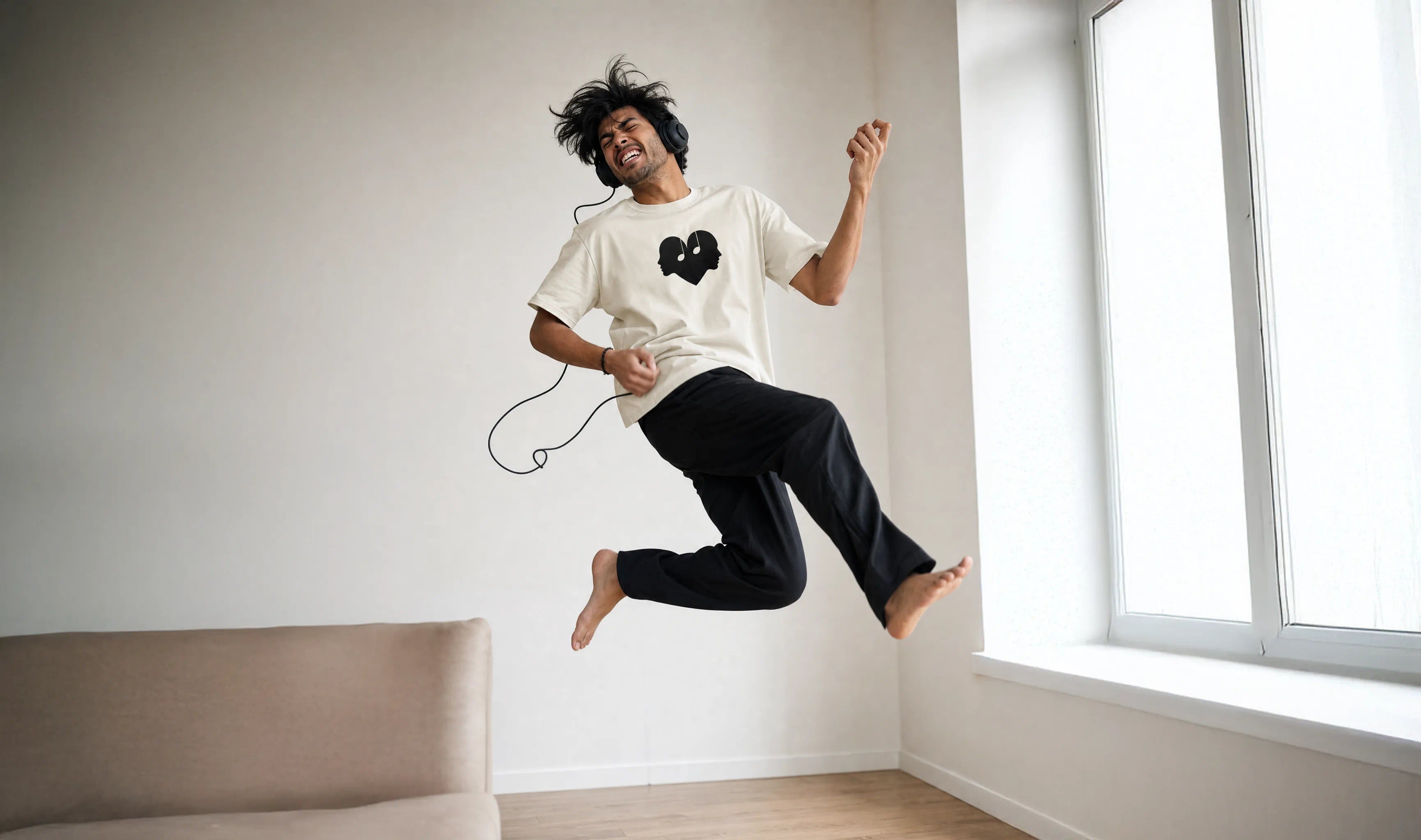 Man leaping in an air guitar jump wearing the Alabaster Overture Oversized Tee with The Symbol on the chest