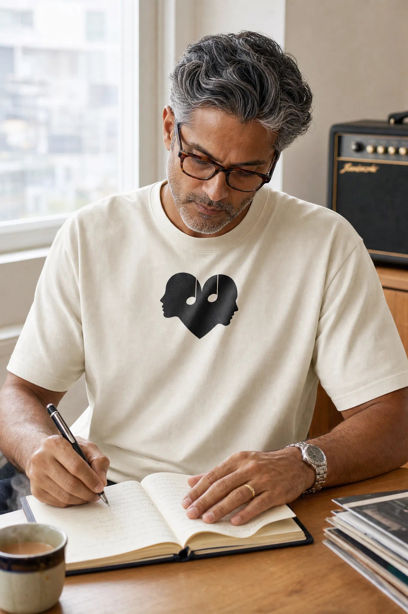 Man writing a letter in the Alabaster Overture Oversized Tee