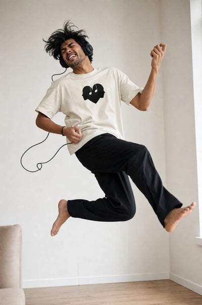 Man jumping mid air playing air guitar in the Alabaster Overture Oversized Tee