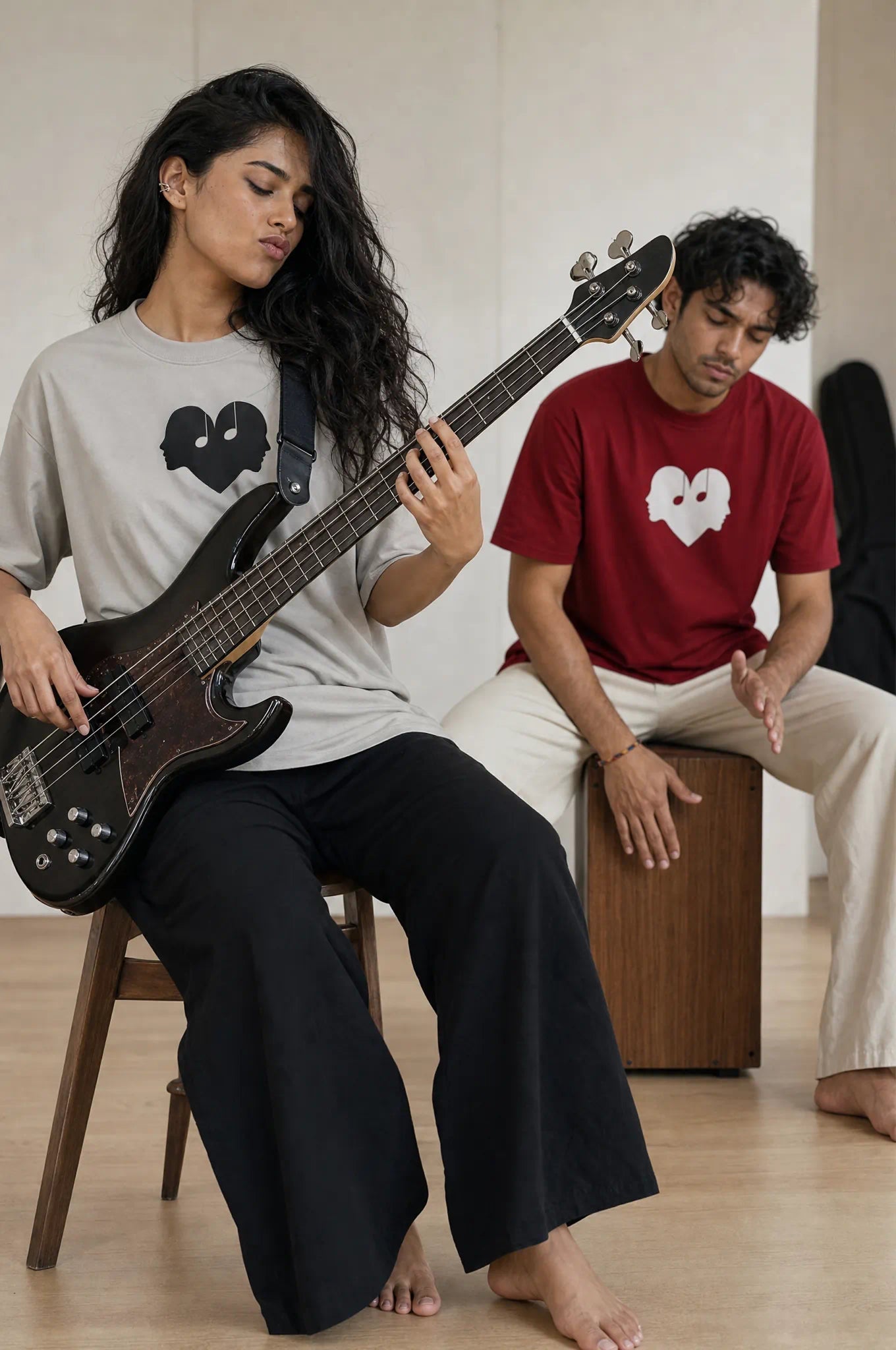 Two friends in Ash and Crimson Overture Oversized Tees playing bass and drums