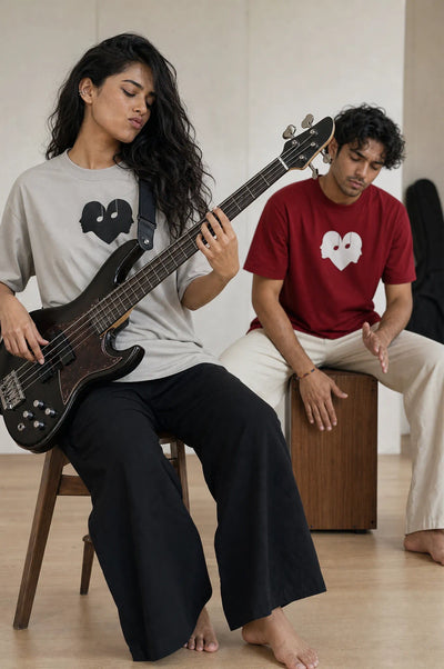 Two friends in Ash and Crimson Overture Oversized Tees playing bass and drums
