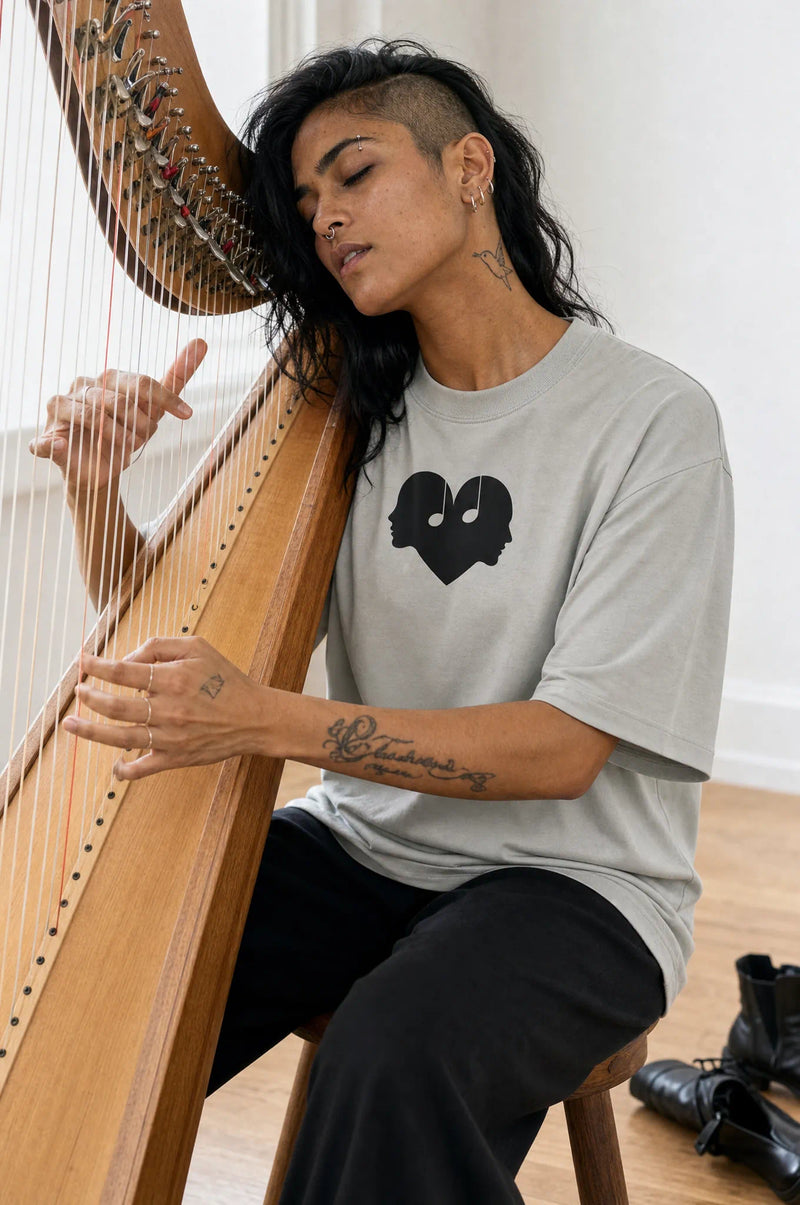 Woman playing a harp in the Ash Overture Oversized Tee