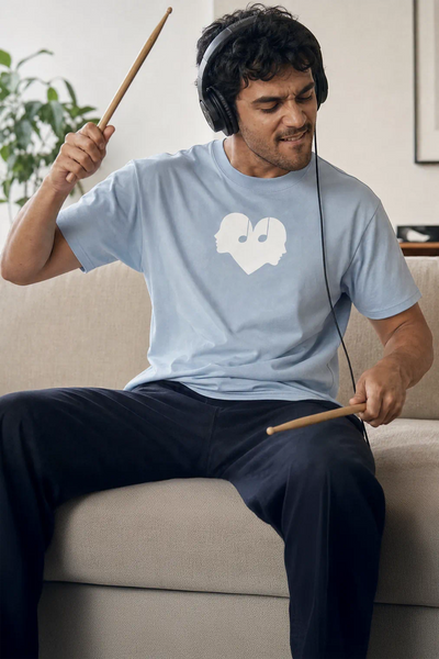 Man playing air drums in the Horizon blue Overture Oversized Tee