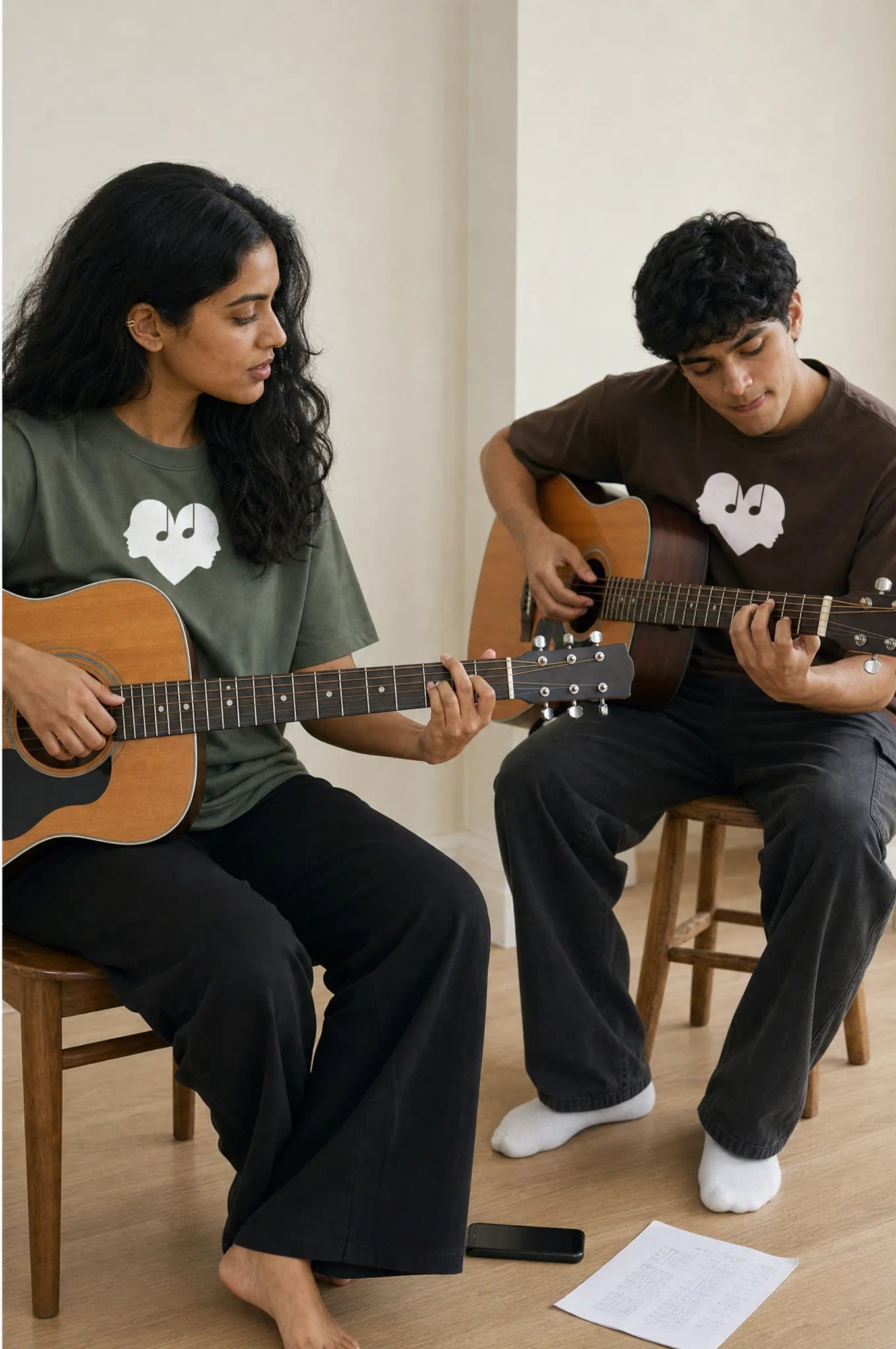 Duet of a woman in Juniper and a man in Mocha Overture Oversized Tees playing acoustic guitar together
