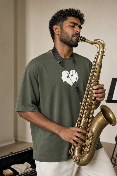 Man playing the saxophone in the Juniper green Overture Oversized Tee