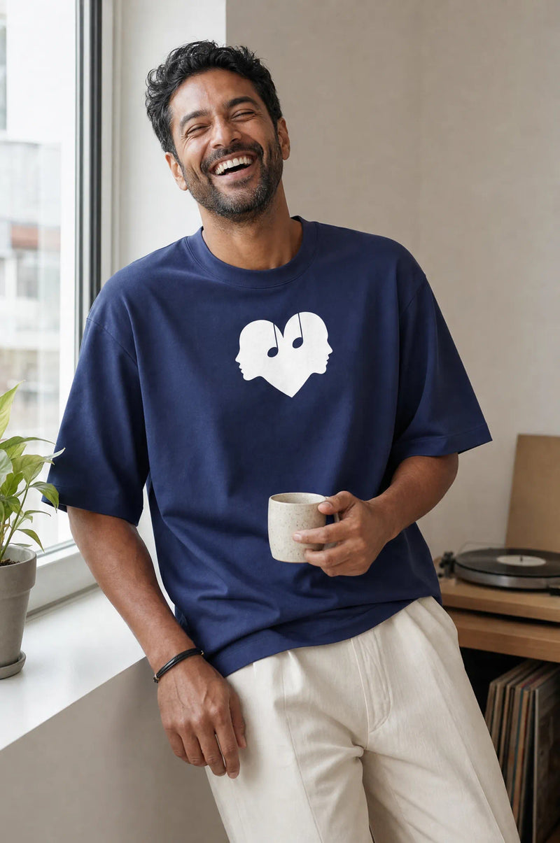 Man with coffee laughing in the Midnight blue Overture Oversized Tee