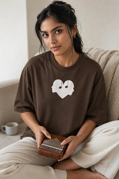 Woman playing a kalimba in the Mocha Overture Oversized Tee